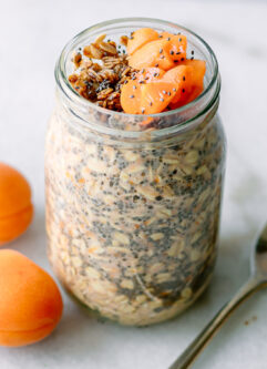 apricot flavored overnight oats garnished with granola and cut apricots on a white table