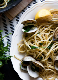 a plate of pasta with clams (pasta con vongole) with fresh parsley