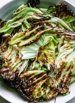 crispy baked cabbage leaves chips in a bowl on a white table