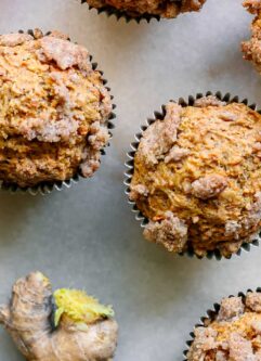 carrot cake muffins with a ginger brown sugar crumble on top on a white table