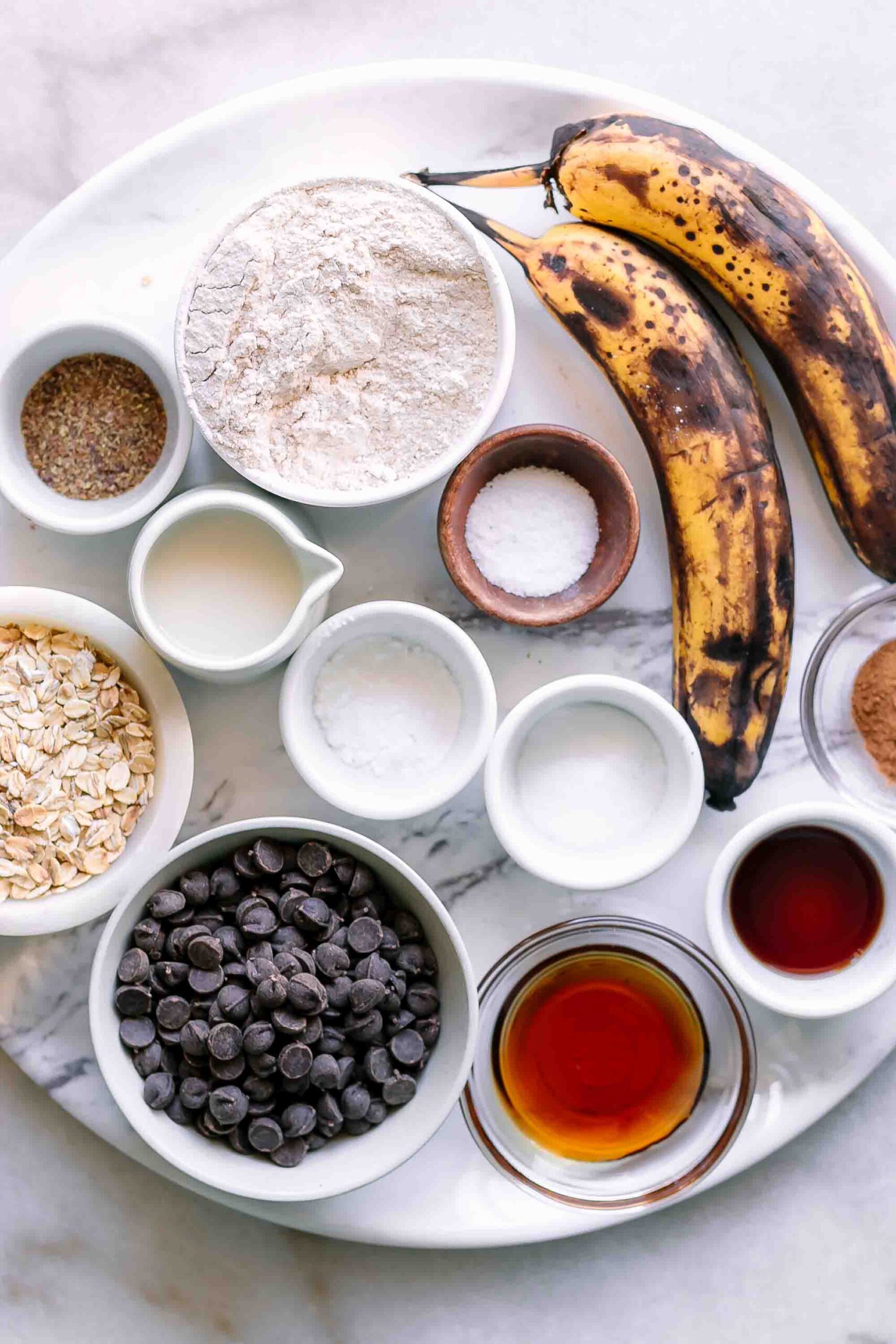 bananas, chocolate chips, flour, rolled oats, baking soda, and other ingredients for plant-based banana bread muffins
