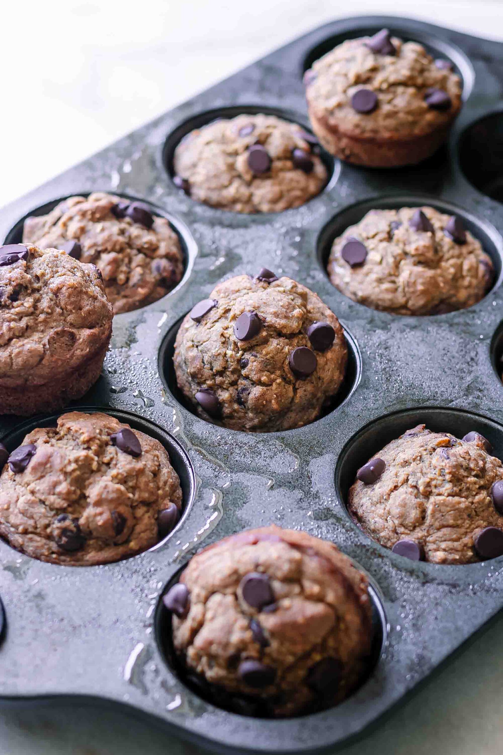 vegan banana bread muffins in a muffin tin after baking