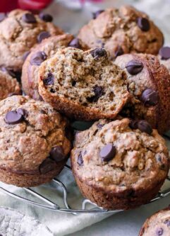 vegan banana bread muffins with dark chocolate chips on a cooking rack on a white table