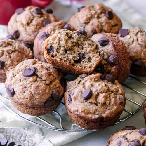 vegan banana bread muffins with dark chocolate chips on a cooking rack on a white table
