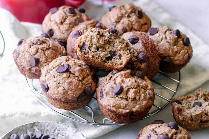 vegan banana bread muffins with dark chocolate chips on a cooking rack on a white table
