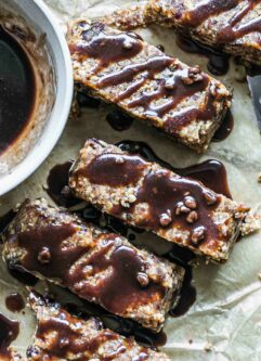 homemade granola bars with chocolate drizzled on top on parchment paper
