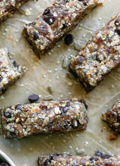 cut homemade snack bars made with tahini, rolled oats, seeds, chocolate, and dates
