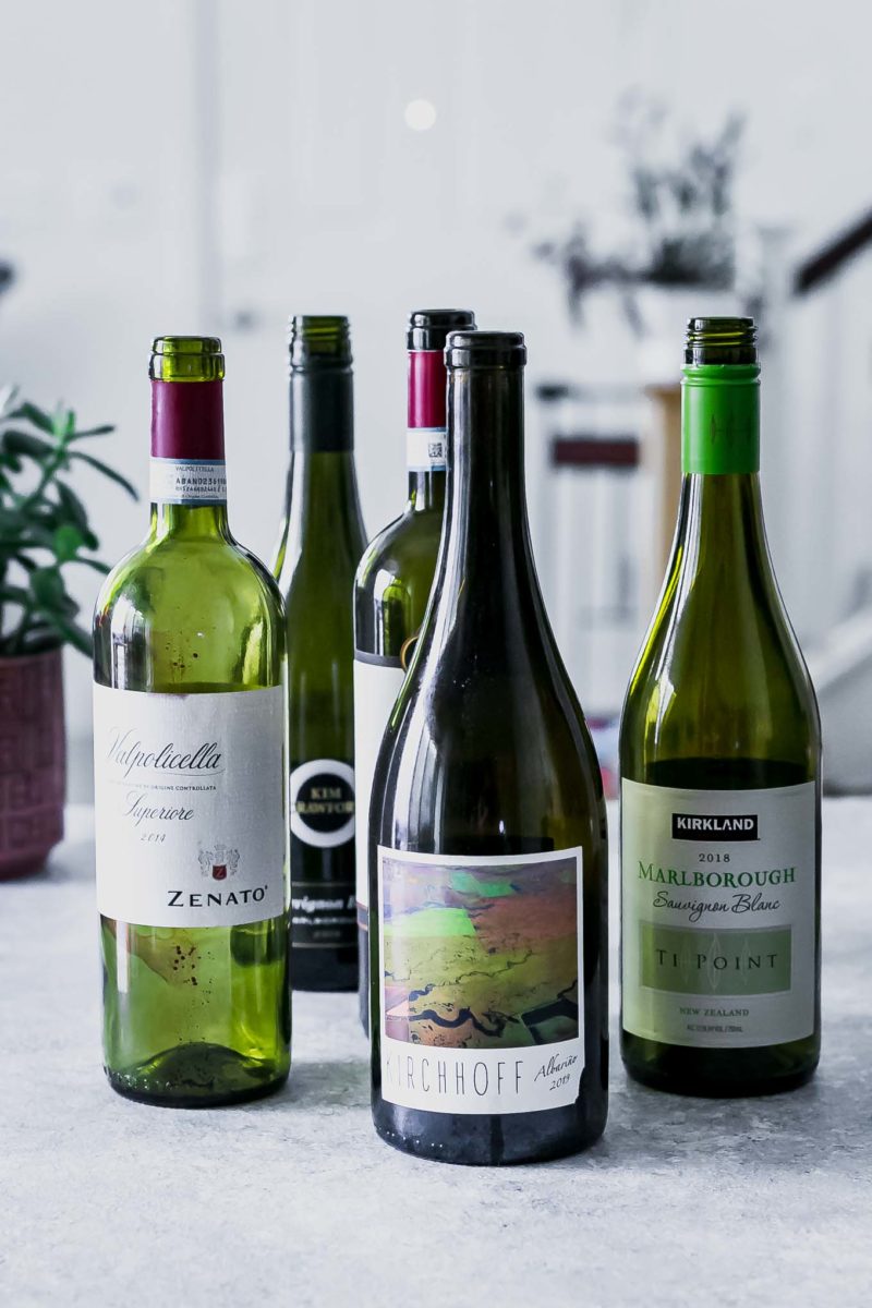 empty wine bottles with labels on a white table