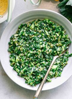 collard greens pesto in a white bowl with a gold fork