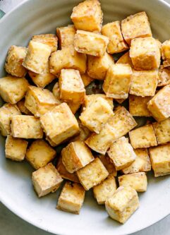 a bowl with crispy baked tofu on a white table