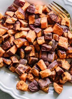 crispy roasted sweet potatoes on a white plate
