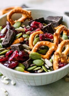 a small bowl with dark chocolate and dried cranberry trail mix with pretzels and seeds