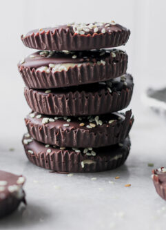 a stack of dark chocolate tahini cups on a white table