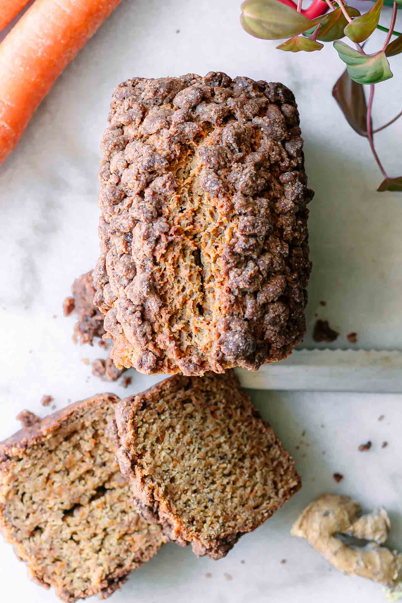 sliced carrot cake bread on a white table with a knife