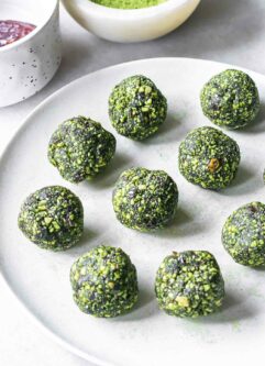 green energy ball snack bites with matcha powder on a white plate