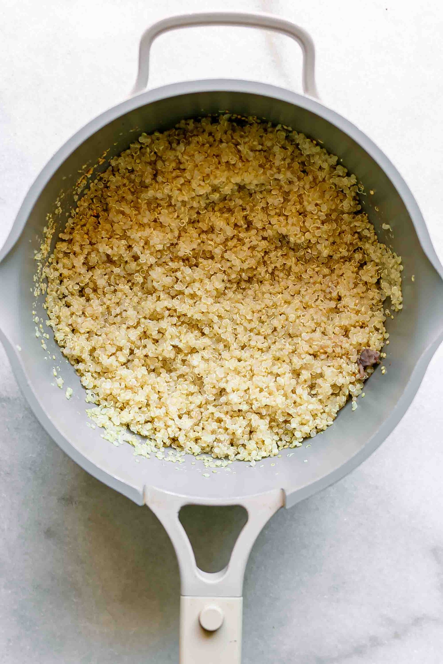 cooked quinoa in a small pot on a white table