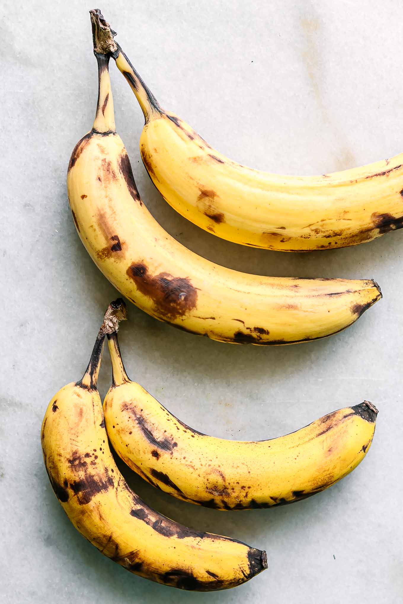 four bananas on a white countertop
