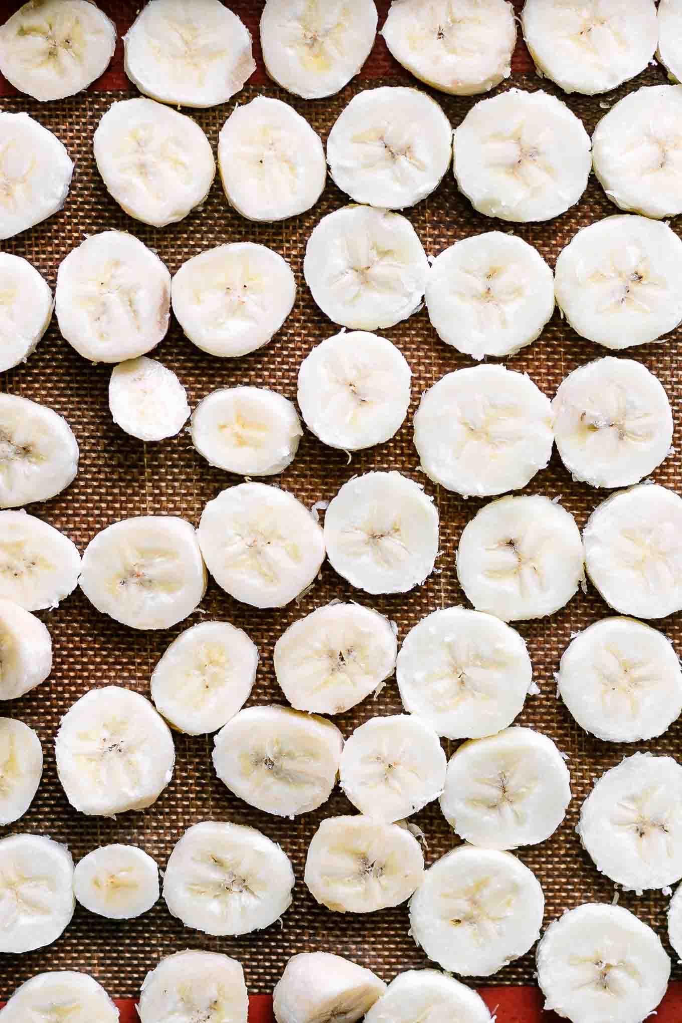 frozen bananas in a single layer on a baking sheet after flash freezing