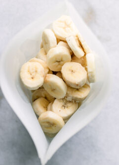 a silicone freezer bag with frozen sliced bananas on a white table
