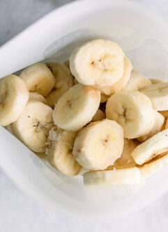 a freezer bag with frozen banana slices on a white table