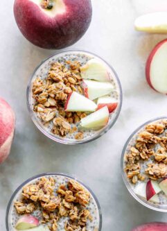 chia pudding with peaches and granola on a white table with fresh peaches