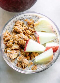 a bowl of peach chia seed pudding with granola and sliced peaches as garnish