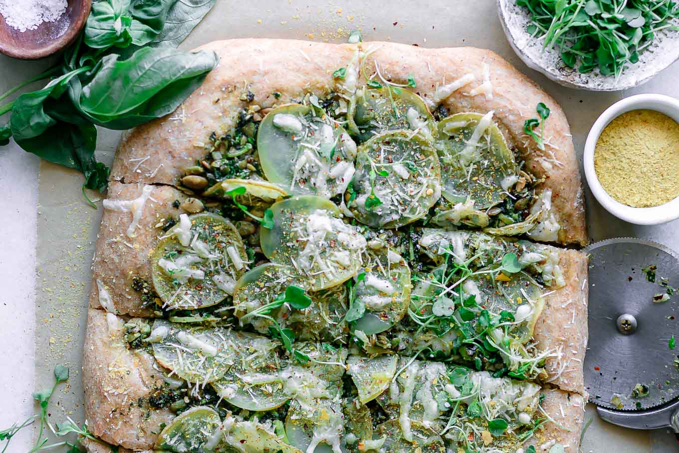 a pizza topped with micro greens and lemon zest