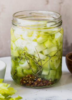 refrigerator pickled celery in a jar on a white table