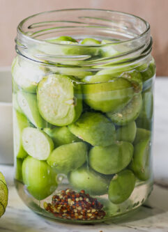 refrigerator pickled tomatillos in a jar on a white table