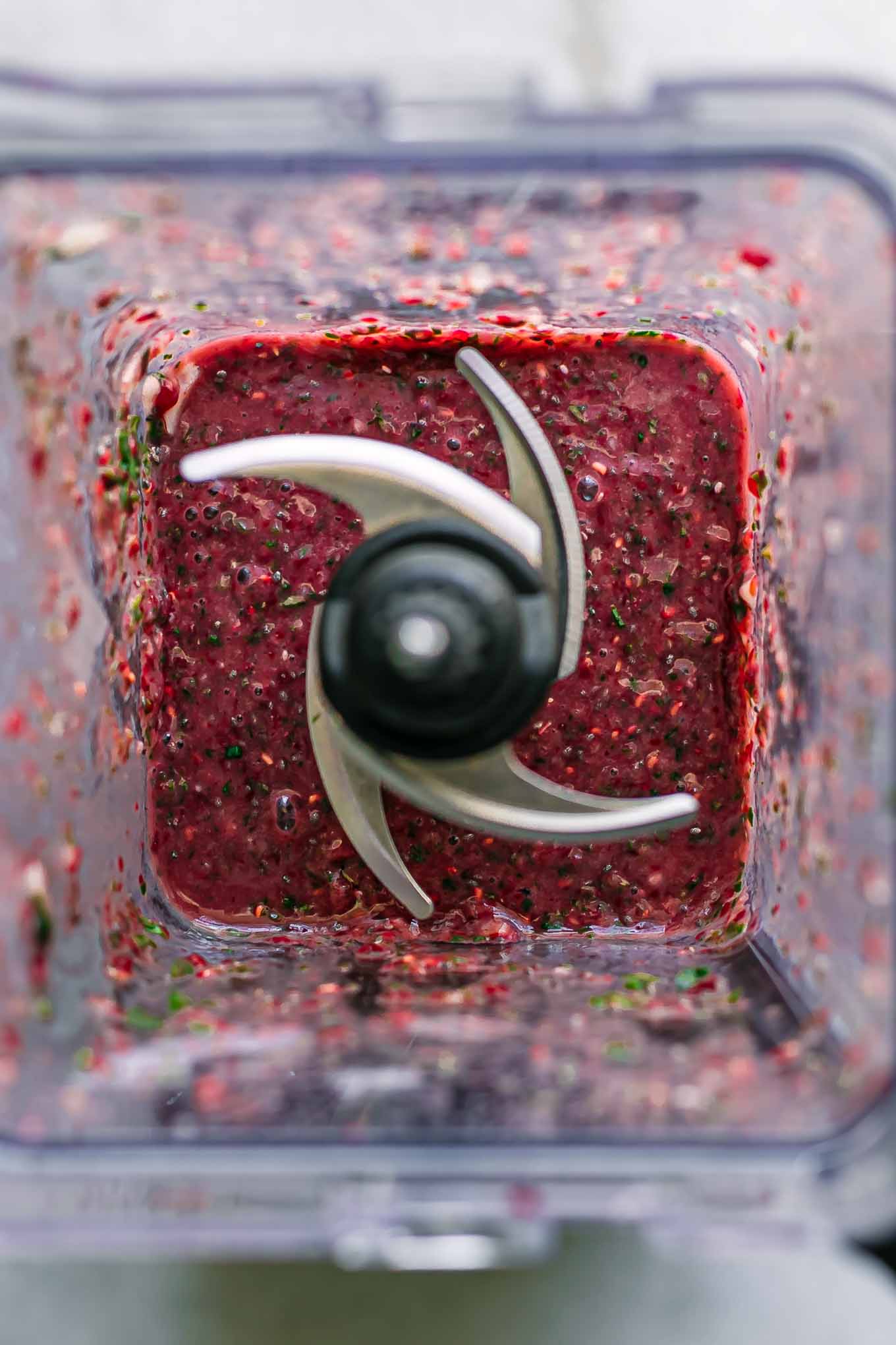 a blended spinach and raspberries smoothie inside a blender