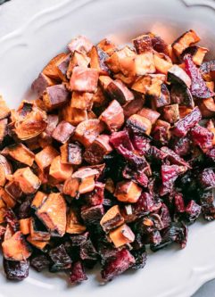 baked beets and sweet potatoes on a white serving plate on a white table