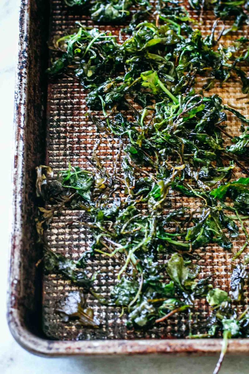 baked arugula leaves on a sheet pan