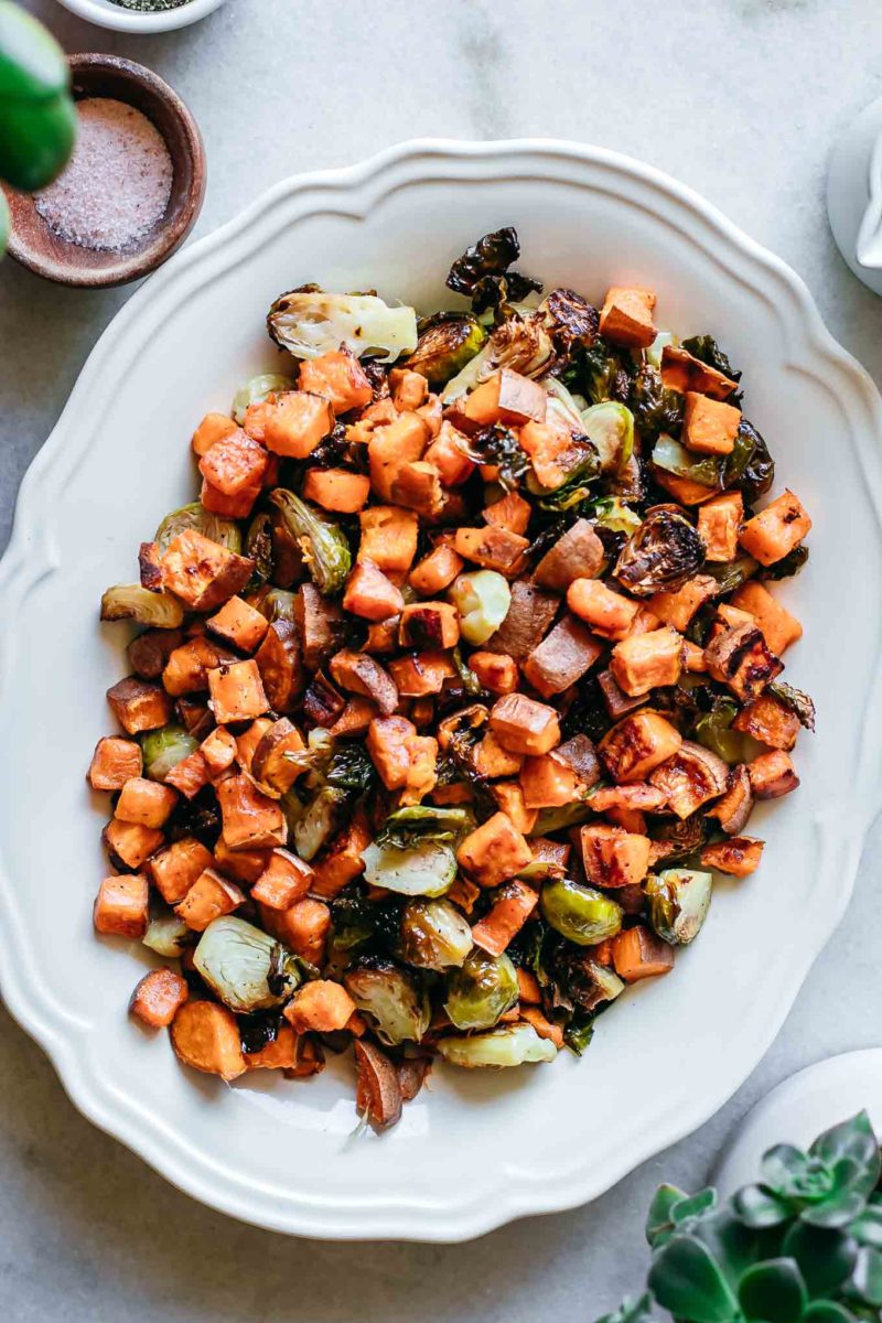 roasted brussels sprouts and sweet potatoes in a serving dish