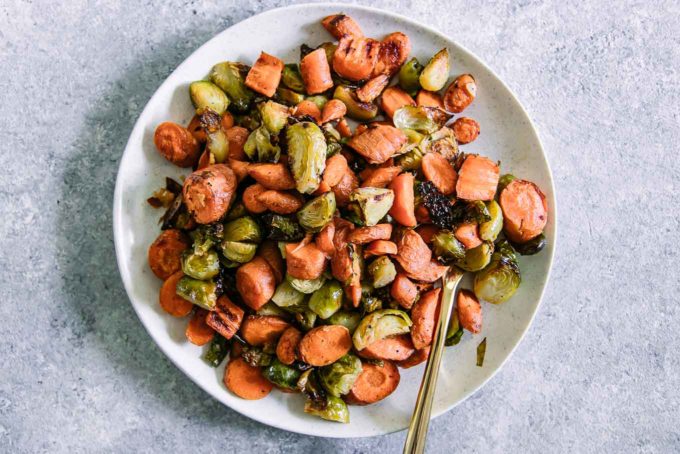 roasted carrots and brussels sprouts on a white p