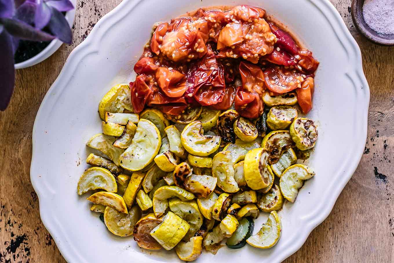 roasted yellows summer squash and tomatoes on a white plate on wood table