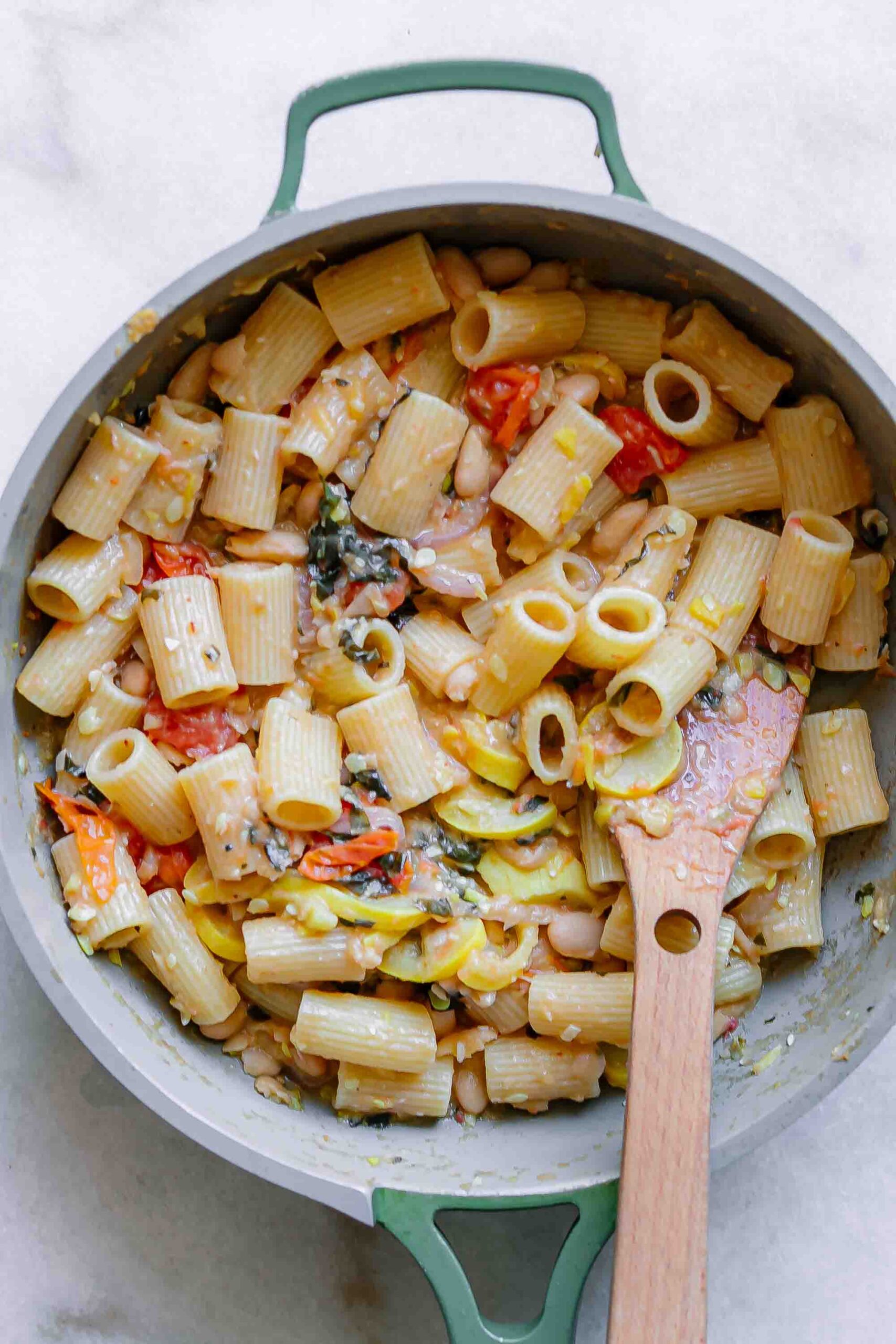 a pan with rigatoni pasta and a creamy vegetable white bean sauce