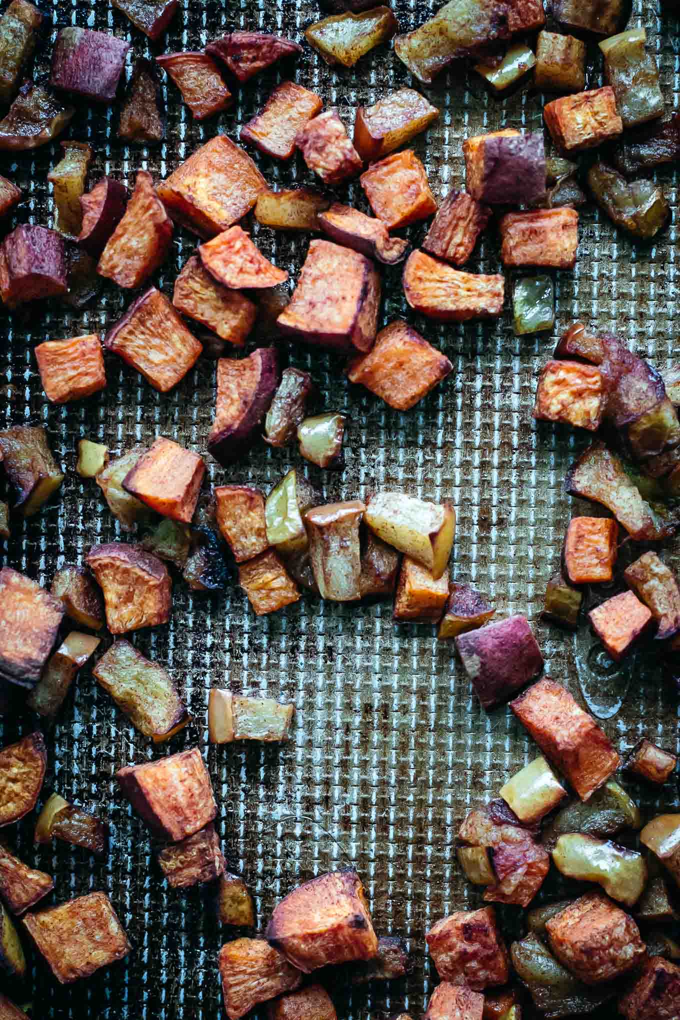 cooked sweet potatoes and apples on a baking sheet
