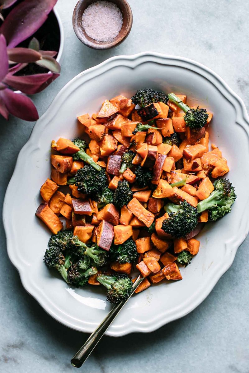 baked broccoli and sweet potatoes on a plate with a gold fork