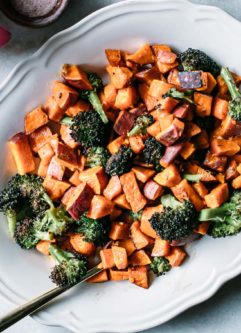 oven roasted sweet potatoes and broccoli on a white plate on a marble countertop