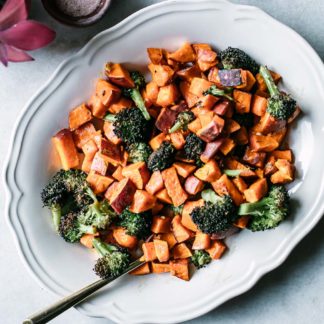 oven roasted sweet potatoes and broccoli on a white plate on a marble countertop