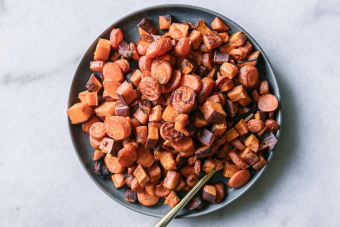 baked sweet potatoes and carrots on a blue plate