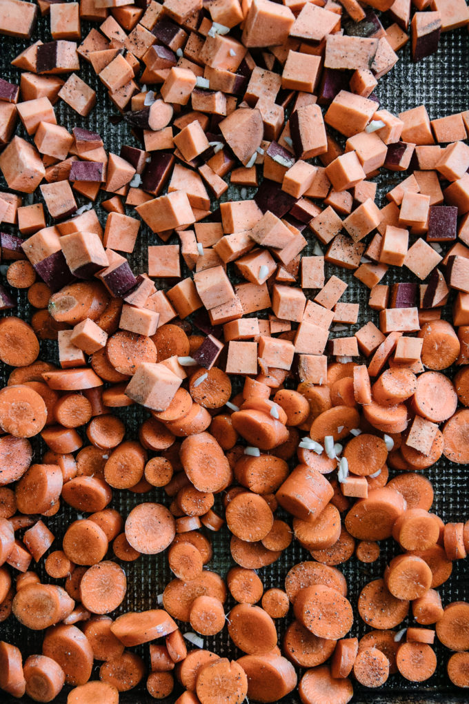 sweet potatoes cut into small cubes and sliced carrots on a cutting board