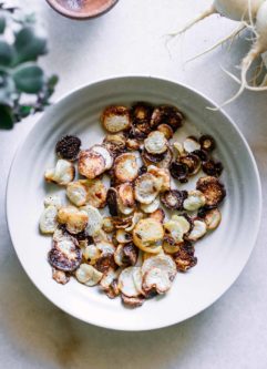 white bowl containing baked turnip chips
