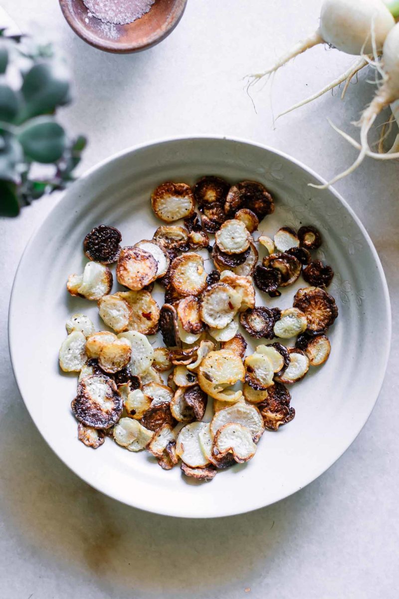 white bowl containing baked turnip chips