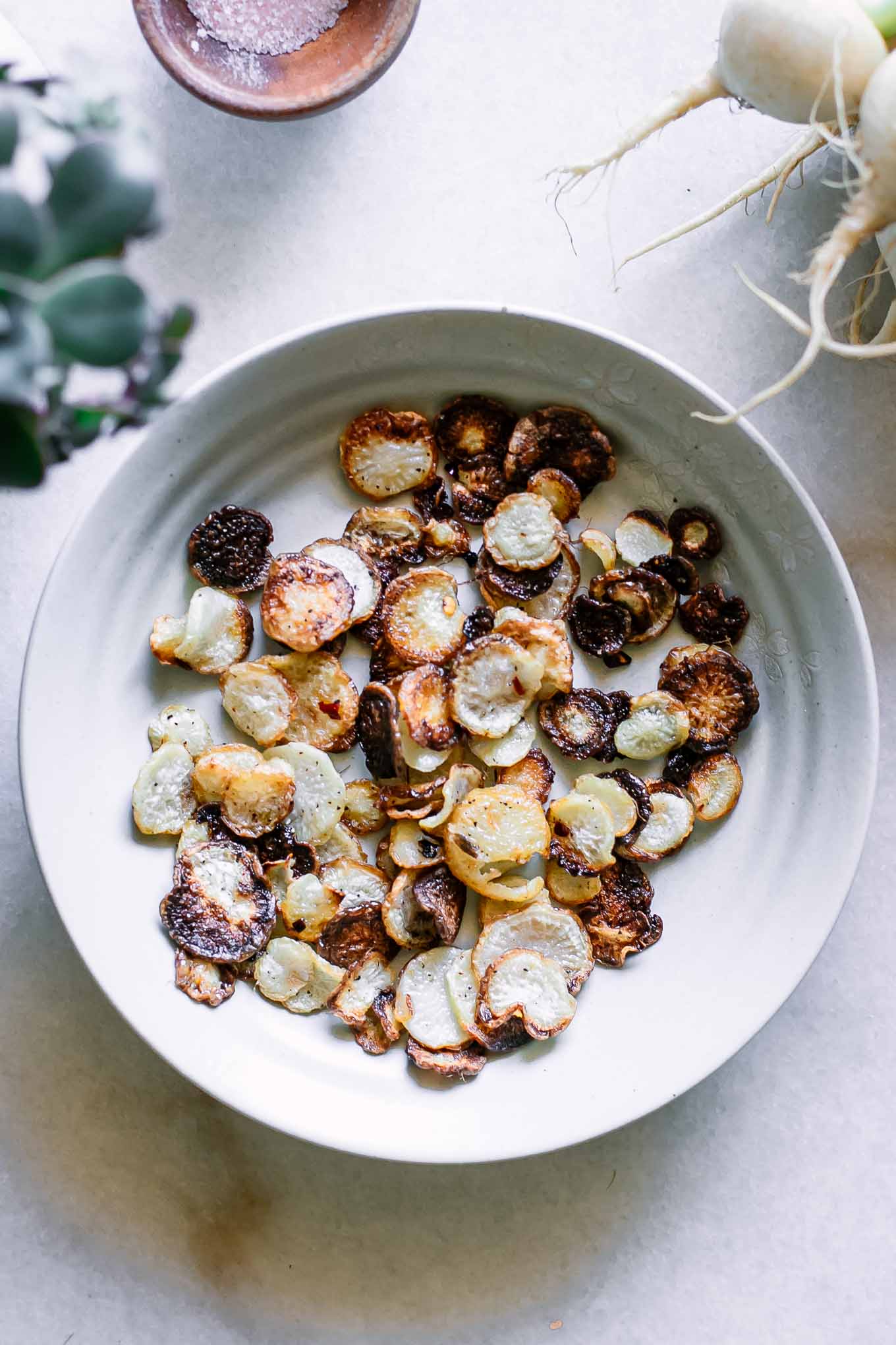 white bowl containing baked turnip chips