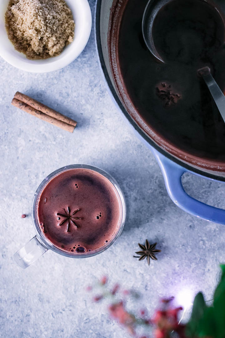 a punch bowl of gluwhein with a wine glass and a cinnamon stick