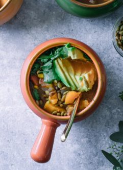 butternut squash chili in an orange soup bowl with a gold spoon