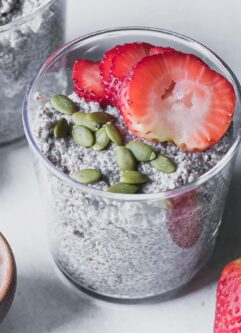 a glass jar with strawberry chia pudding on a white table