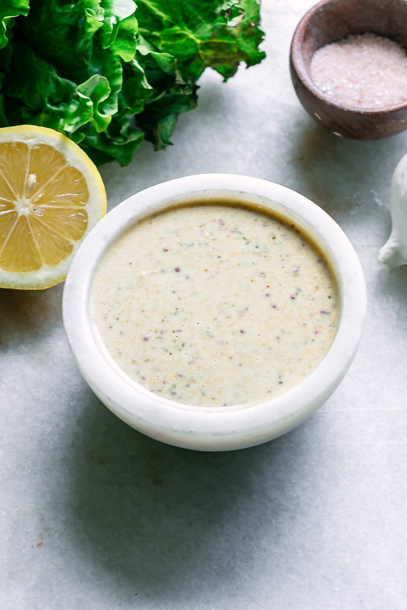 a bowl of caesar dressing without anchovies, eggs, or parmesan cheese on a white table