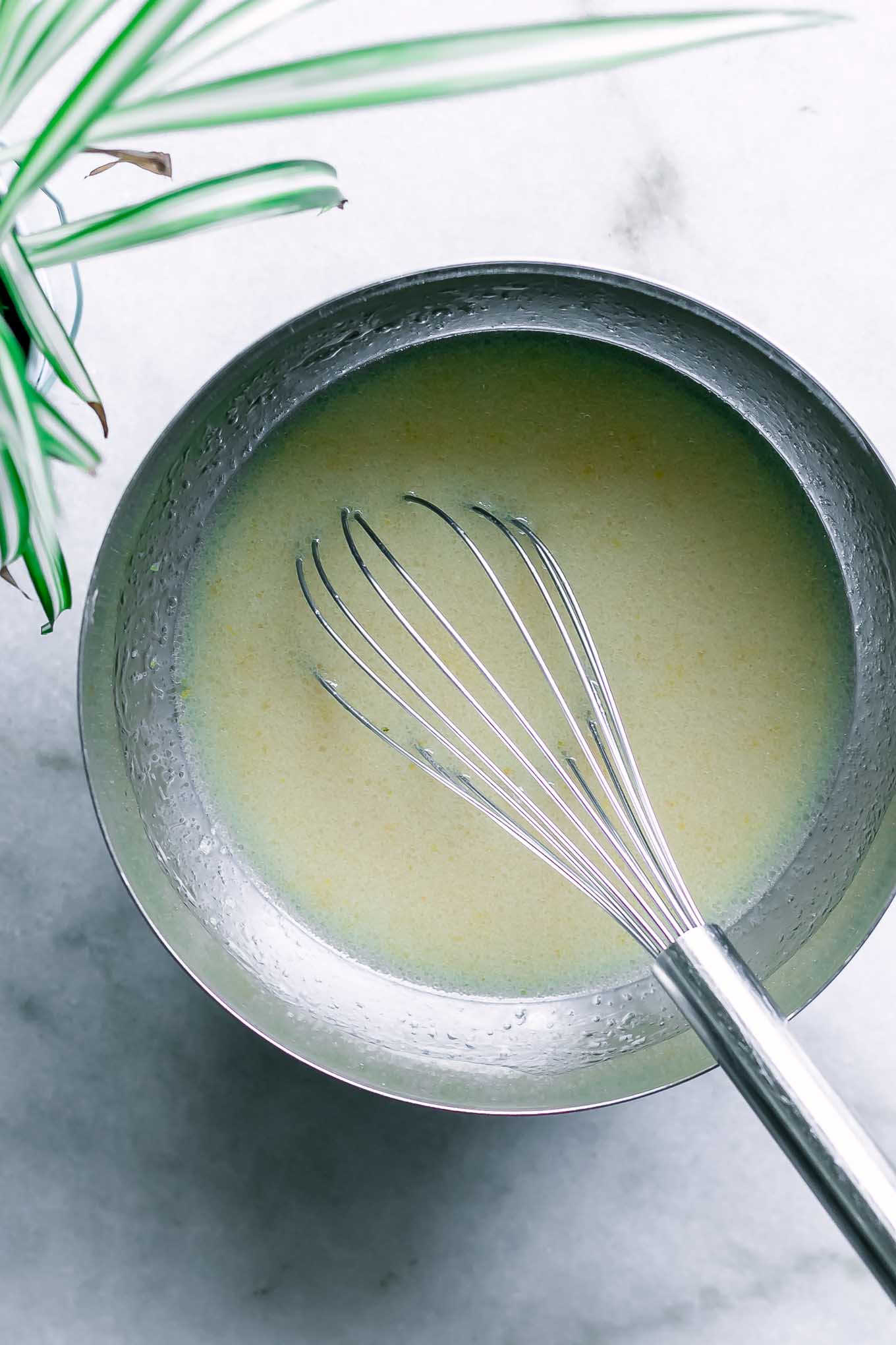 wet ingredients for muffins inside a bowl with a whisk
